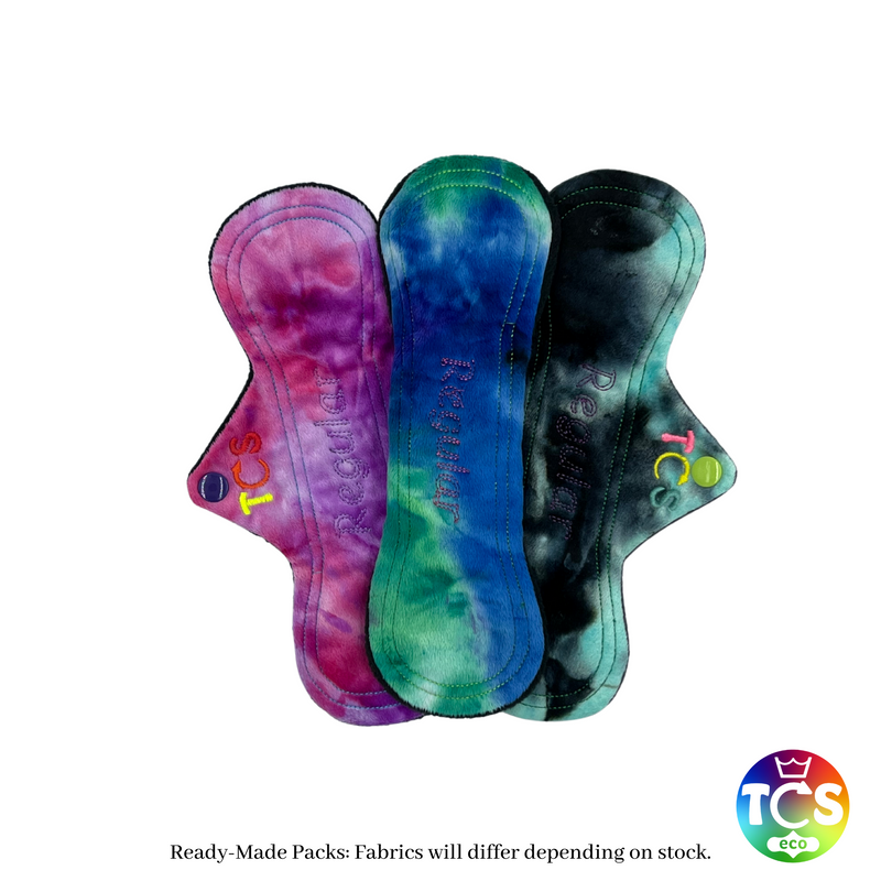 An example Starter pack from TCS-eco.  The Cloth Sanitary Pads with a brightly coloured cotton Jersey top fabric.  The 3 pads are 9 inch in length and slim width.  This shape is designed for smaller framed people.  These cloth sanitary pads are designed for teenagers and smaller framed people. 9 inch pads are the most popular length of day disposable.